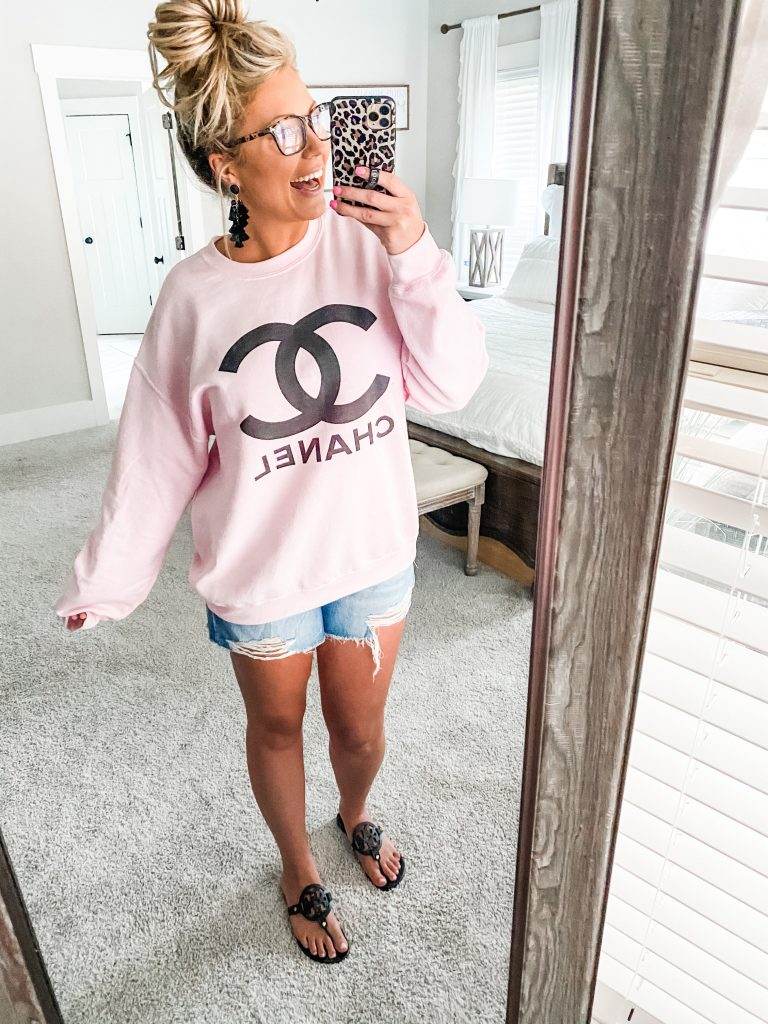 Smiling while taking a selfie in the pink Chanel sweater and blue light glasses