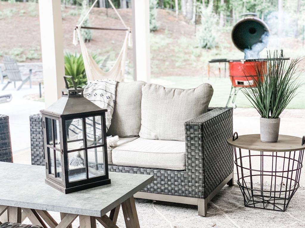 Patio loveseat, with a wire endtable, coffeetable and lamp decoration.