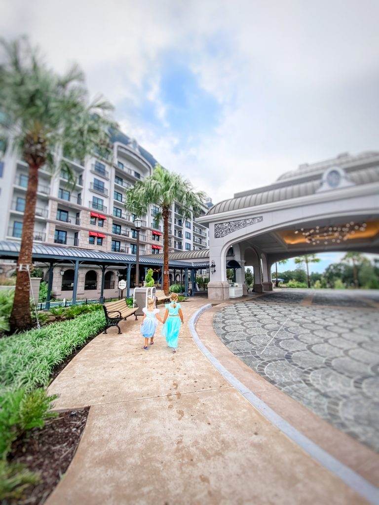 Sisters hold hands walking a path at the Disney Riviera resort. 